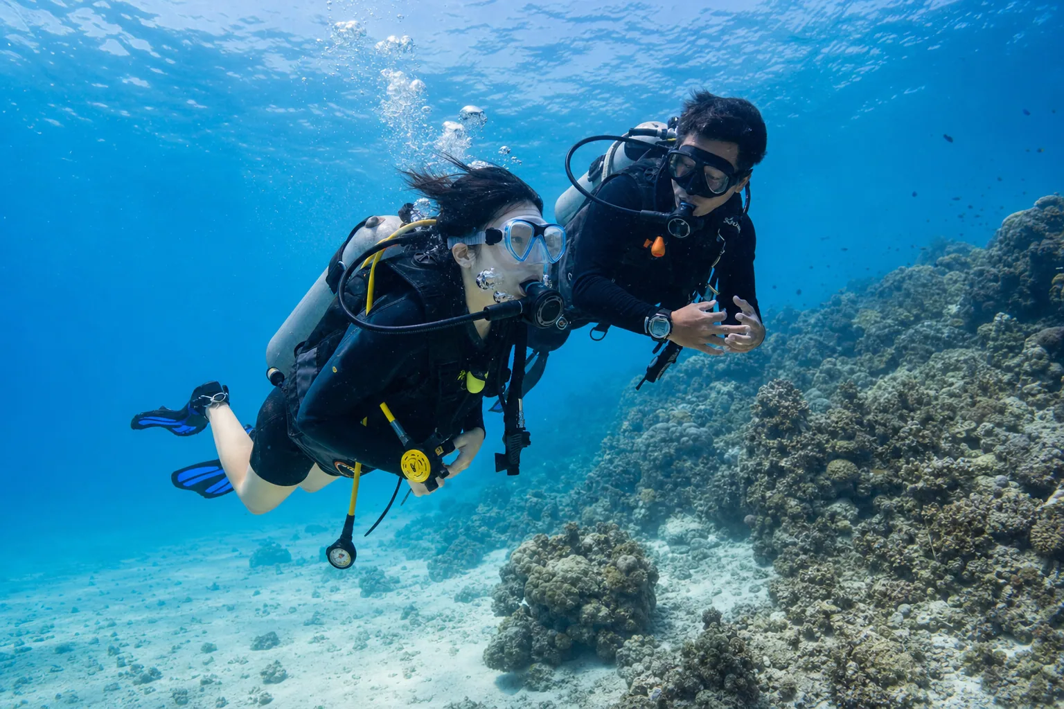First-time scuba diver receiving calm guidance from an instructor in clear shallow water in Siquijor