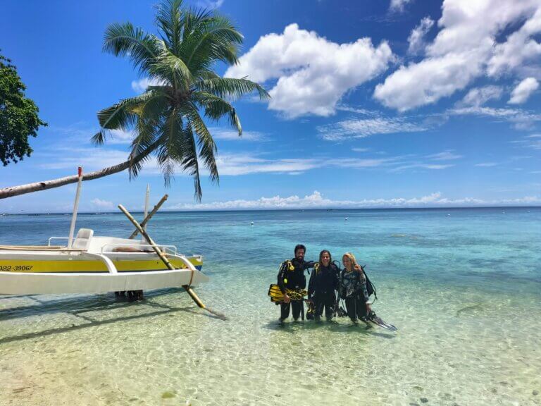 Beautiful island with amazing coral reef full of life and with many turtles living in there, divers after their underwater experience smiling and full of joy